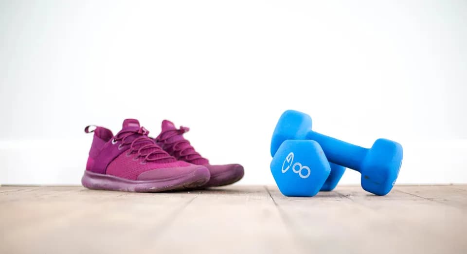 Zapatillas moradas junto a mancuernas